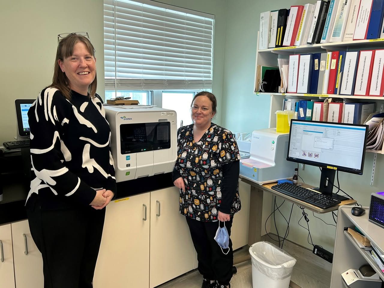 Krista MacKinnon and Holly Manning with the new blood analyzer in the Souris Hospital lab